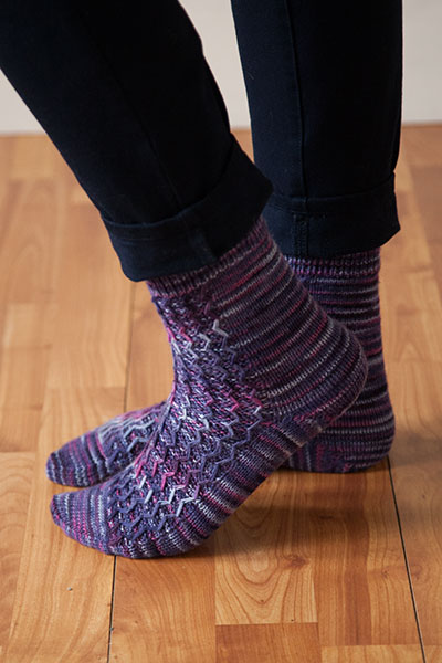 Model's feet on hardwood floor wearing meandering socks.