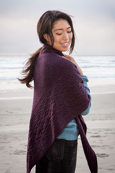 A model on the beach wearing the violet Arisaig shawl.