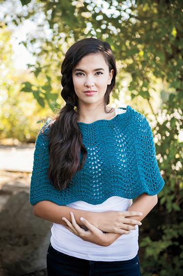 Model wearing the Wearable Waves Wrap with plants and sunshine behind her.