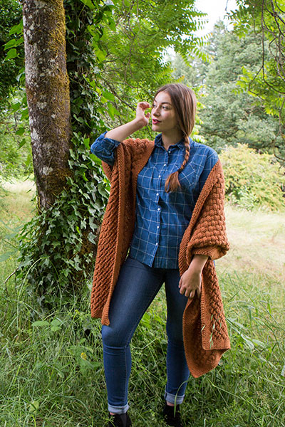 Model wearing the Weft Wrap in a forested area.