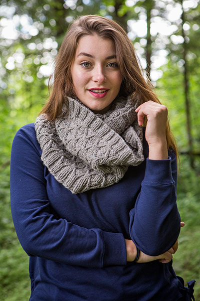 Model wearing the Wynt Cowl in a forested area.