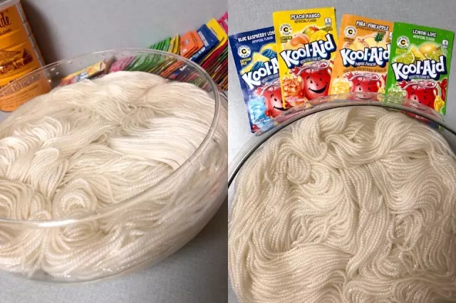 Packs of Kool-Aid nearby a bowl of undyed yarn