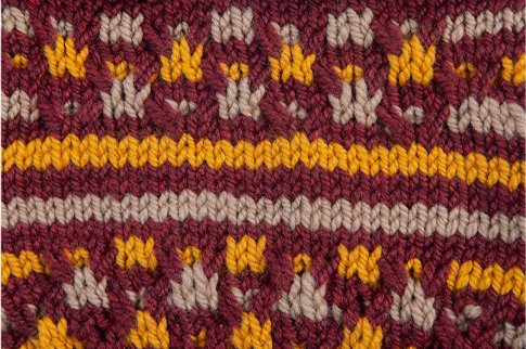 Up close view of the final results of the project, showing the yellow patterns on the red cardigan