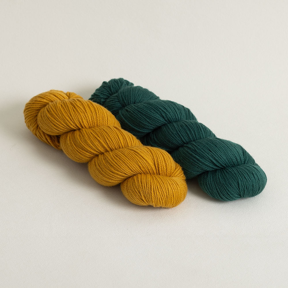 Two hanks of High Desert yarn, a gold yellow and a teal yarn