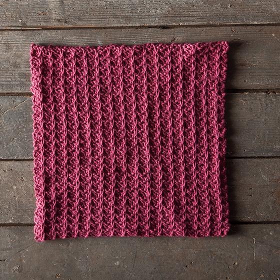 The Slipped Stripes Dishcloth - a red knitted dishcloth with a striped texture